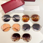 Set of Gucci round sunglasses with tinted lenses, gold frames, and patterned details