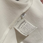 White T-shirt sleeve hem with stitched seam and care label