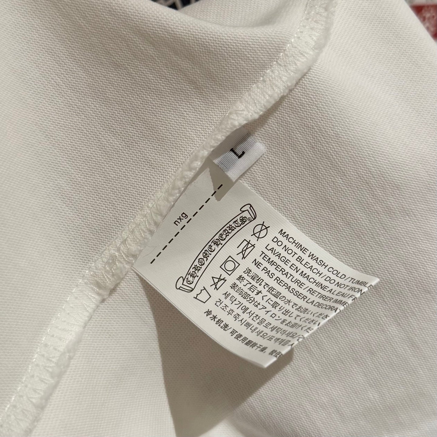 White T-shirt sleeve hem with stitched seam and care label