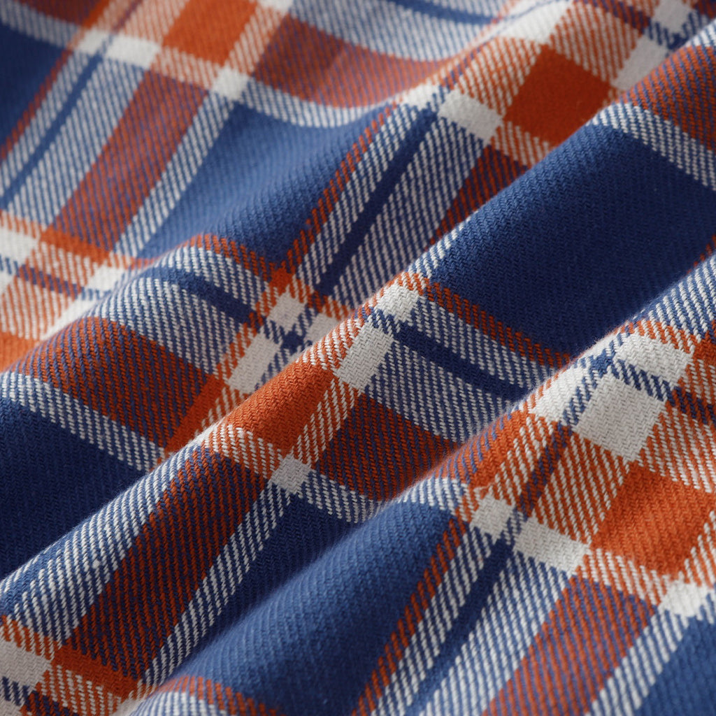 Close-up of plaid woven fabric with blue, orange, and white grid lines.