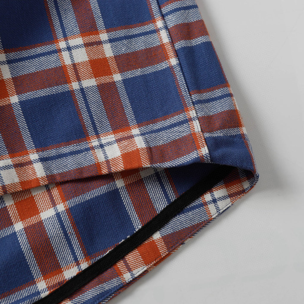 Plaid shirt hem with side edge seam detail and inner facing.