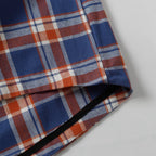 Plaid shirt hem with side edge seam detail and inner facing.