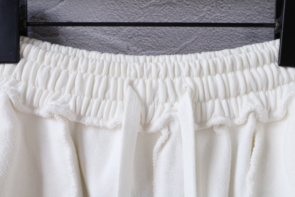 White shorts waistband close-up with ruched elastic and gathered pleats