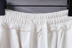 White shorts waistband close-up with ruched elastic and gathered pleats