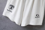 White shorts side view with circular Balenciaga logo print and hem