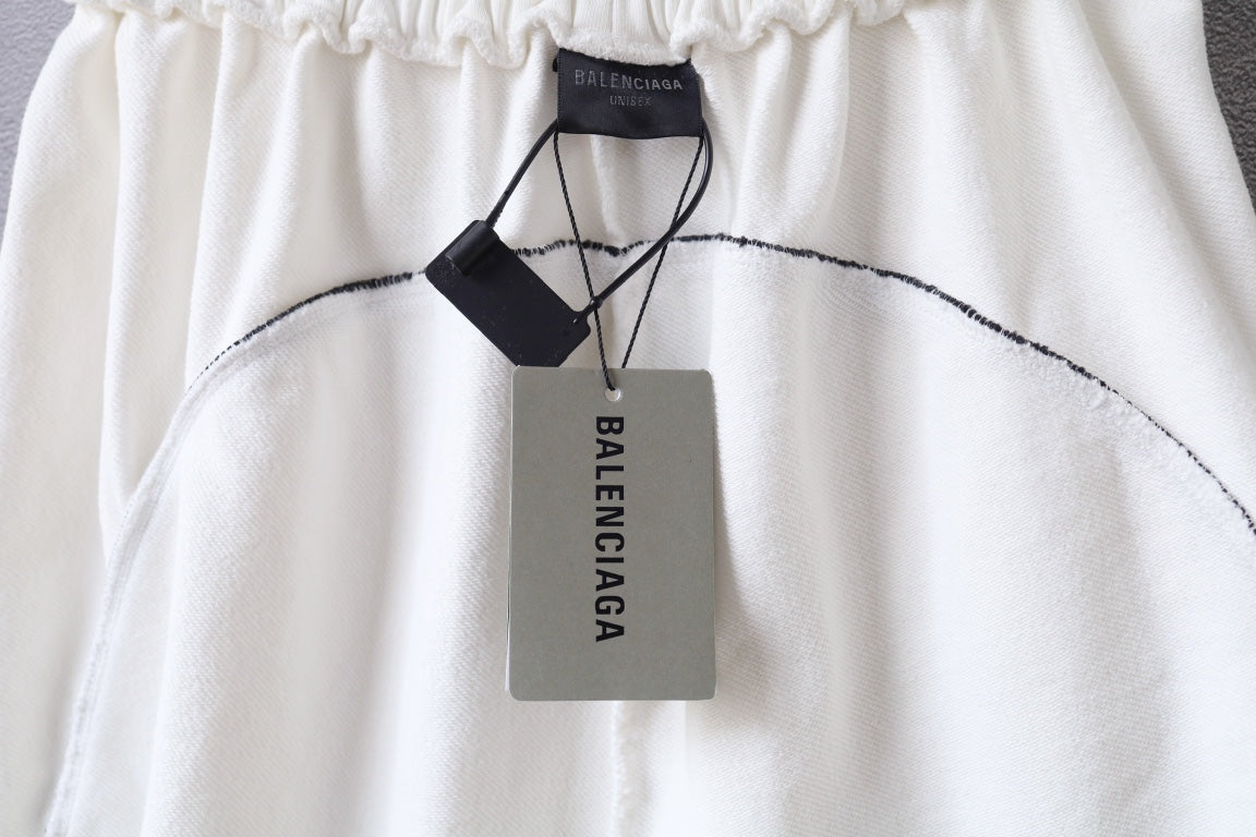 White shorts close-up with black Balenciaga hang tag and looped drawstring