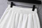 White shorts on a hanger with elastic waistband detailing