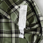 Plaid shirt with interior neck label tag on green, black, and white check fabric