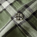 Close-up of plaid shirt button detail on green, black, and white fabric