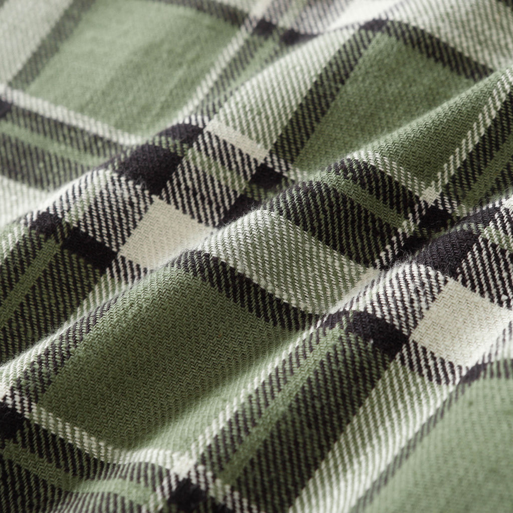 Close-up of green plaid fabric with black and white intersecting stripes