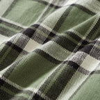 Close-up of green plaid fabric with black and white intersecting stripes