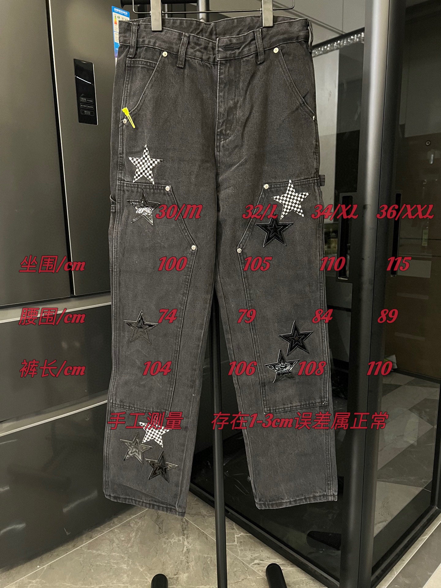 Dark gray denim pants with distressed star patches on both legs