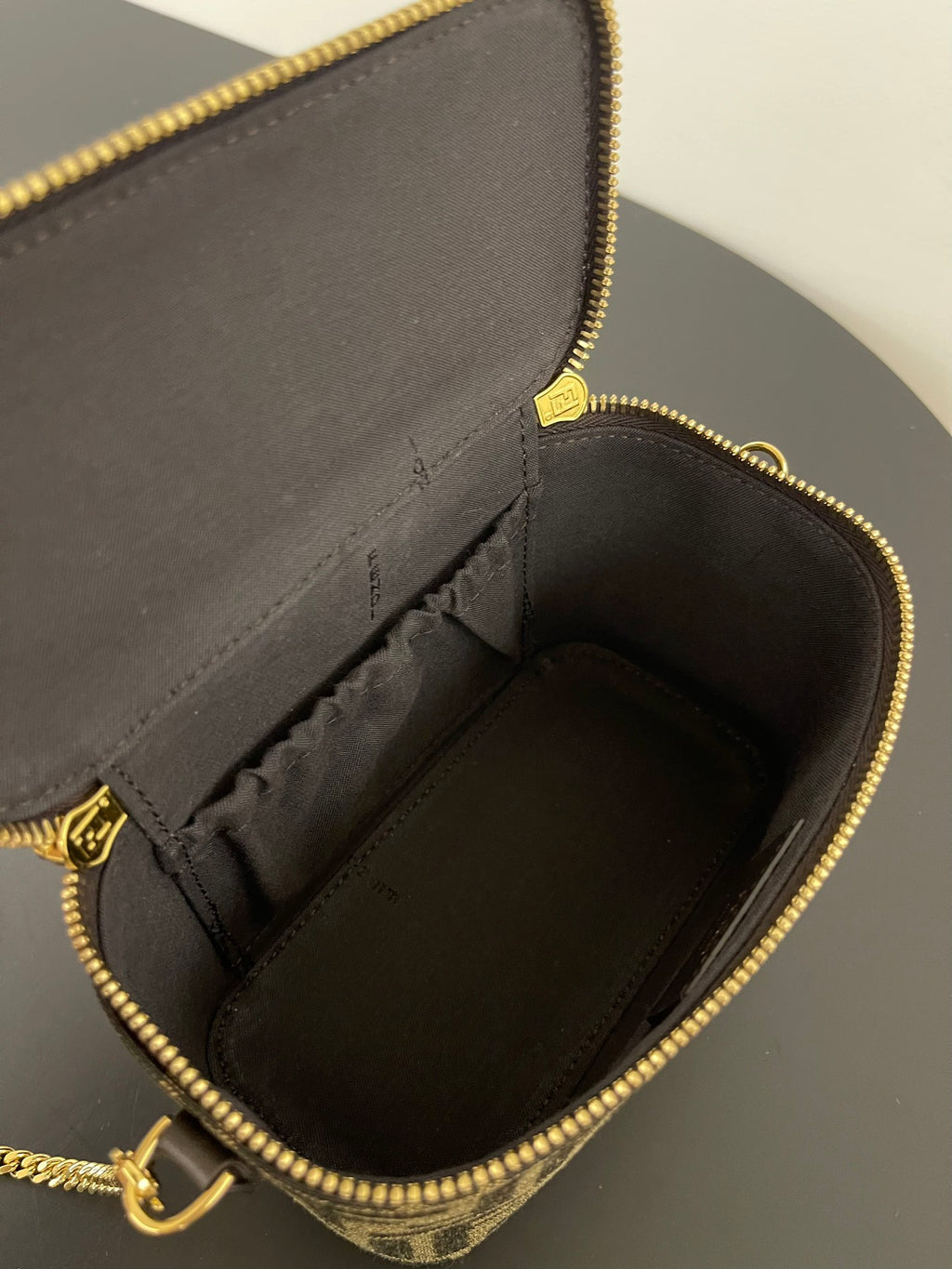 Fendi mini bag open interior with black lining and gold zipper edge