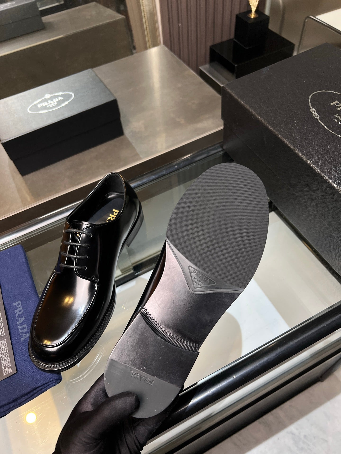 Prada black leather lace-up shoes with spare dark insole, display angle