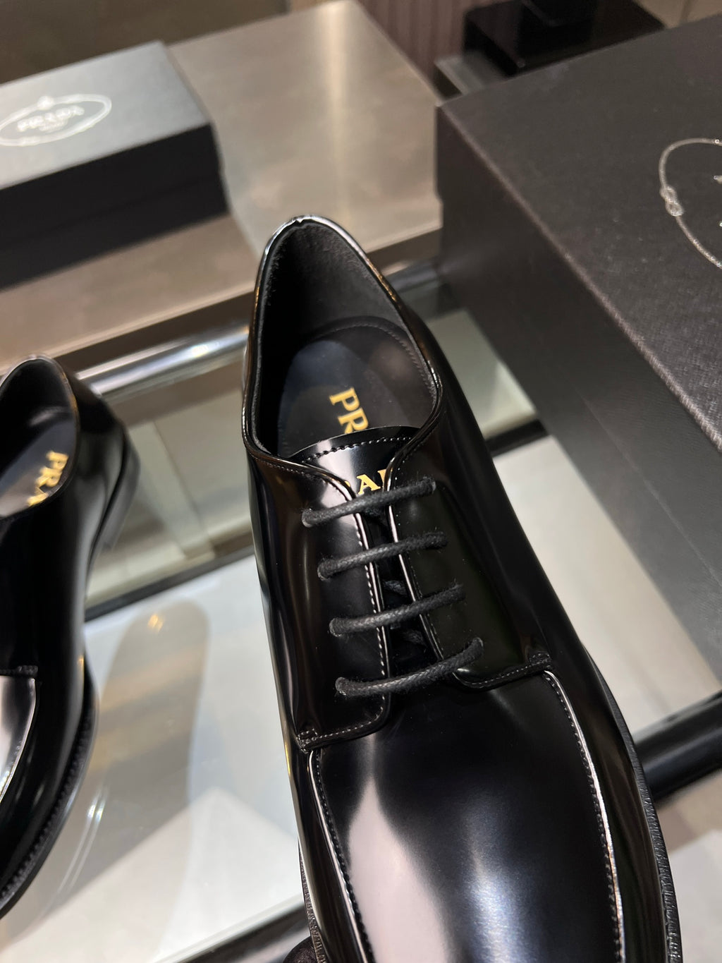 Prada unisex leather lace-up shoe close-up, black glossy leather and lace detail