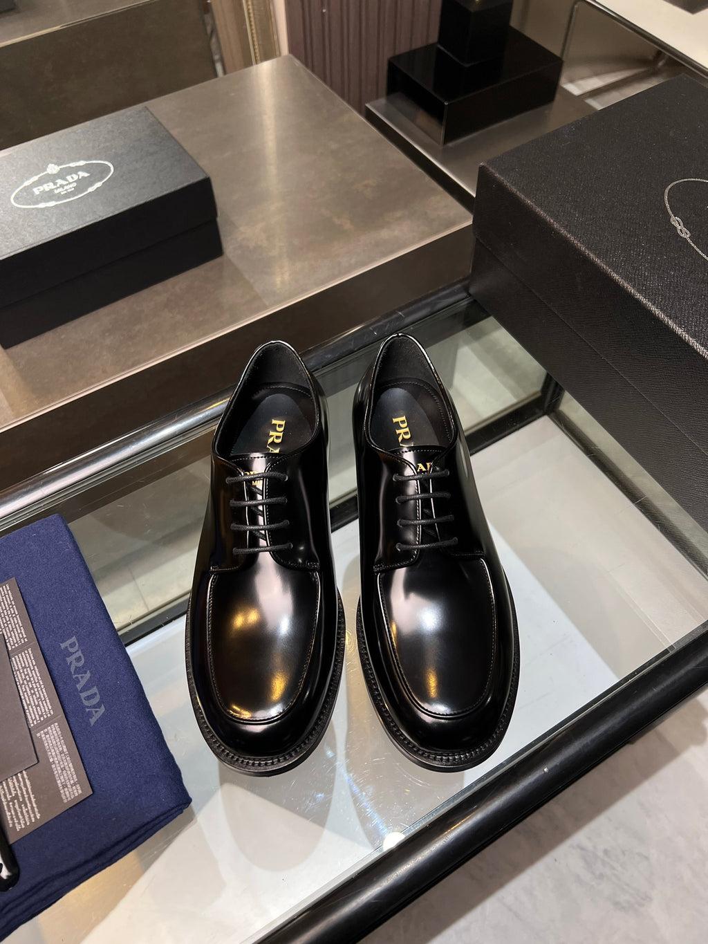 Prada unisex leather lace-up shoes in black, with glossy finish and stitched trim