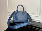 Blue Louis Vuitton handbag with two top handles, textured exterior, gold hardware.