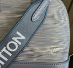 Blue Louis Vuitton strap close-up with bold lettering on textured material.