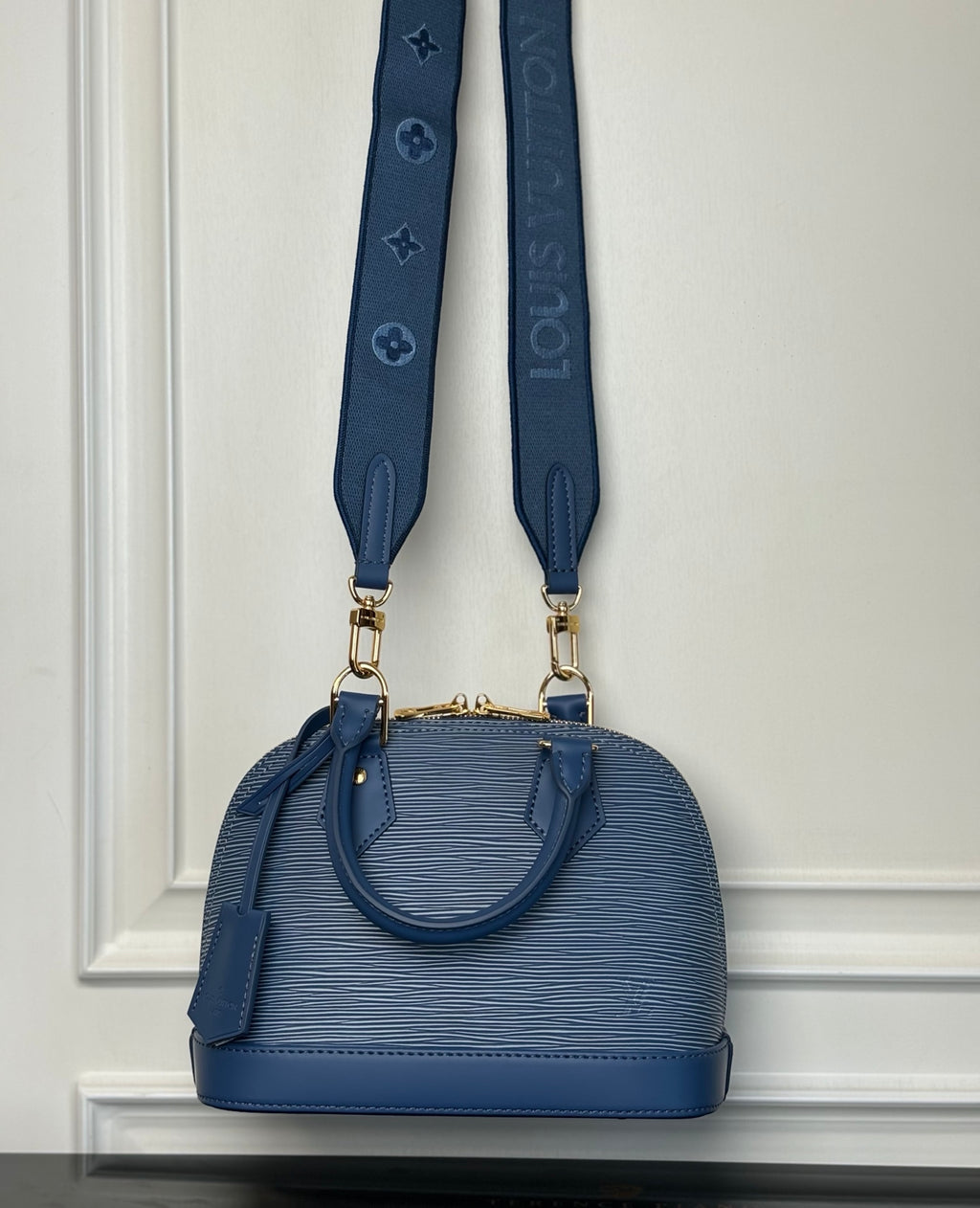Blue Louis Vuitton mini handbag with two shoulder straps and gold hardware.