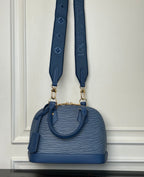 Blue Louis Vuitton mini handbag with two shoulder straps and gold hardware.