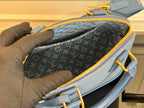 Louis Vuitton handbag open view with dark monogram interior and yellow zipper.