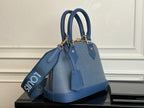 Blue Louis Vuitton handbag angled view with top handles and long crossbody strap.