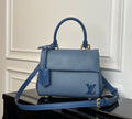Blue textured leather handbag with top handle, front flap, and gold-tone hardware.