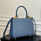 Blue textured handbag with top handles and shoulder strap, gold clasp hardware.