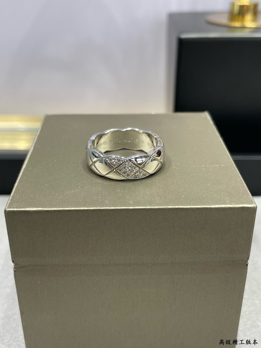 Silver-tone braided ring with cross-over design and sparkling stones on display