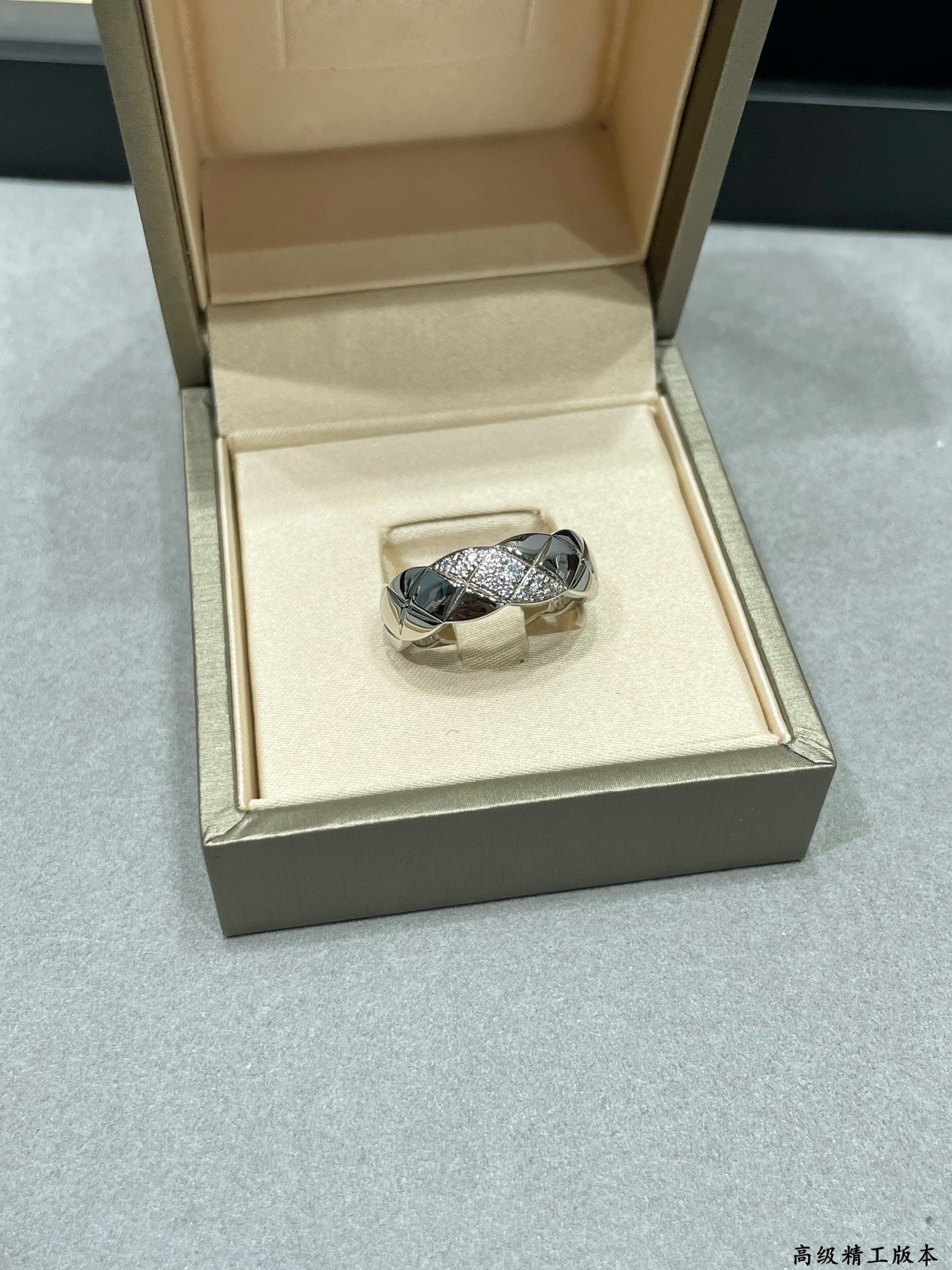 Silver-tone braided ring with sparkling stones in a jewelry box