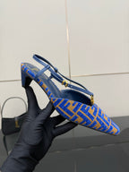 Blue Fendi logo-pattern slingback pump held in hand, side view