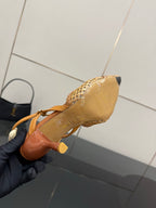 Tan woven heeled sandal showing outsole and stiletto heel, slingback strap.