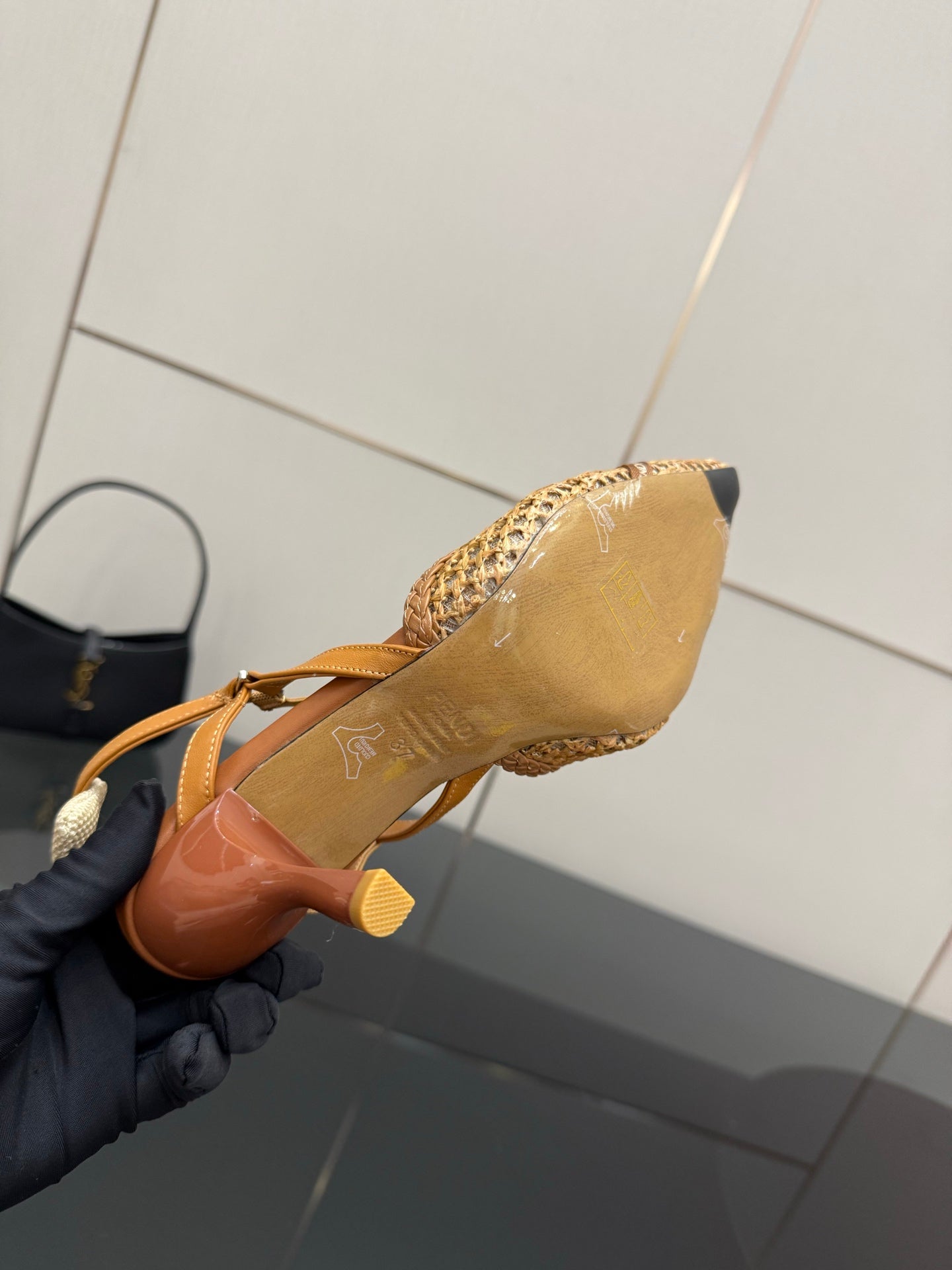 Tan woven heeled sandal showing outsole and stiletto heel, slingback strap.