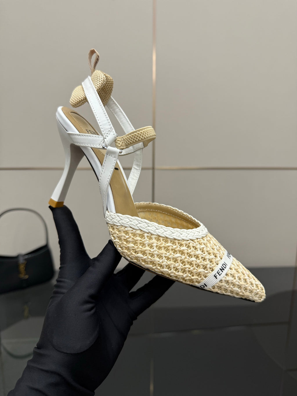 Women’s woven slingback heel shown in hand, pointed toe and stiletto heel, light beige