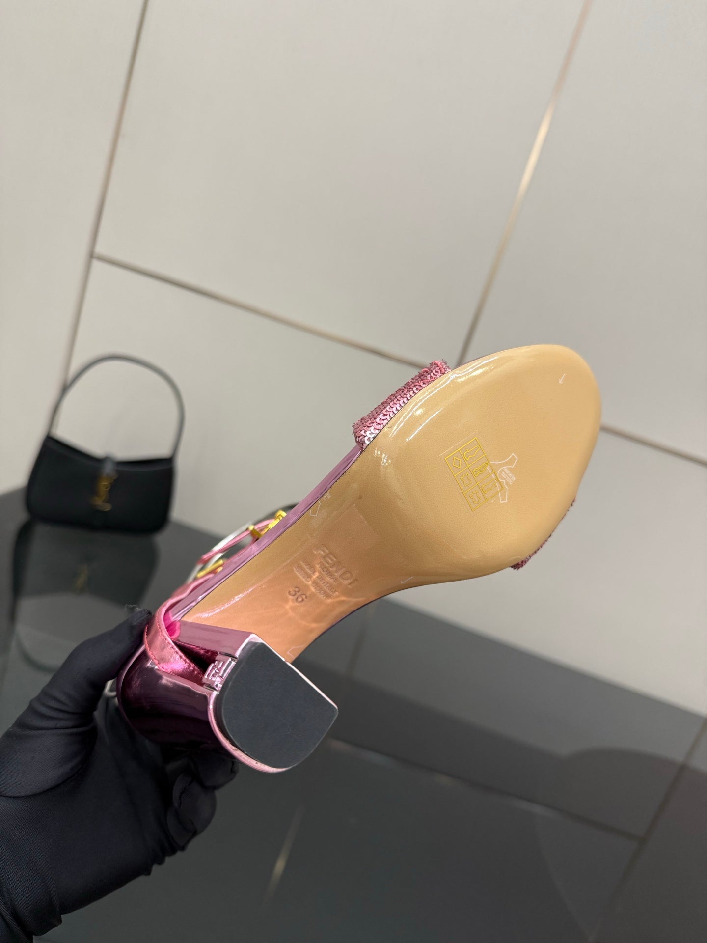 Pink high-heel sandal sole underside with glitter ankle strap edge