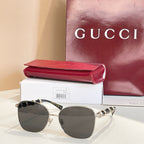 Gold metal round sunglasses with dark gray lenses and black temple accents