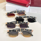 Set of round sunglasses with gold frames, black temples, and tinted lenses