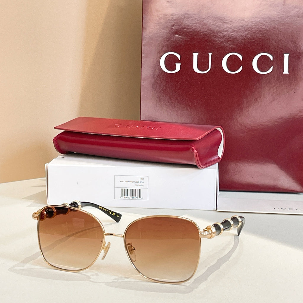 Gold metal round sunglasses with brown tinted lenses and black temple detailing