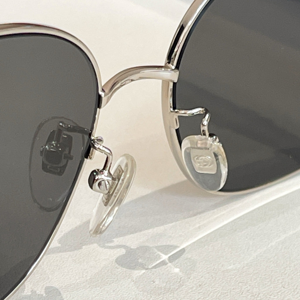 Round black-lens sunglasses with gold metal hinges and temple emblem