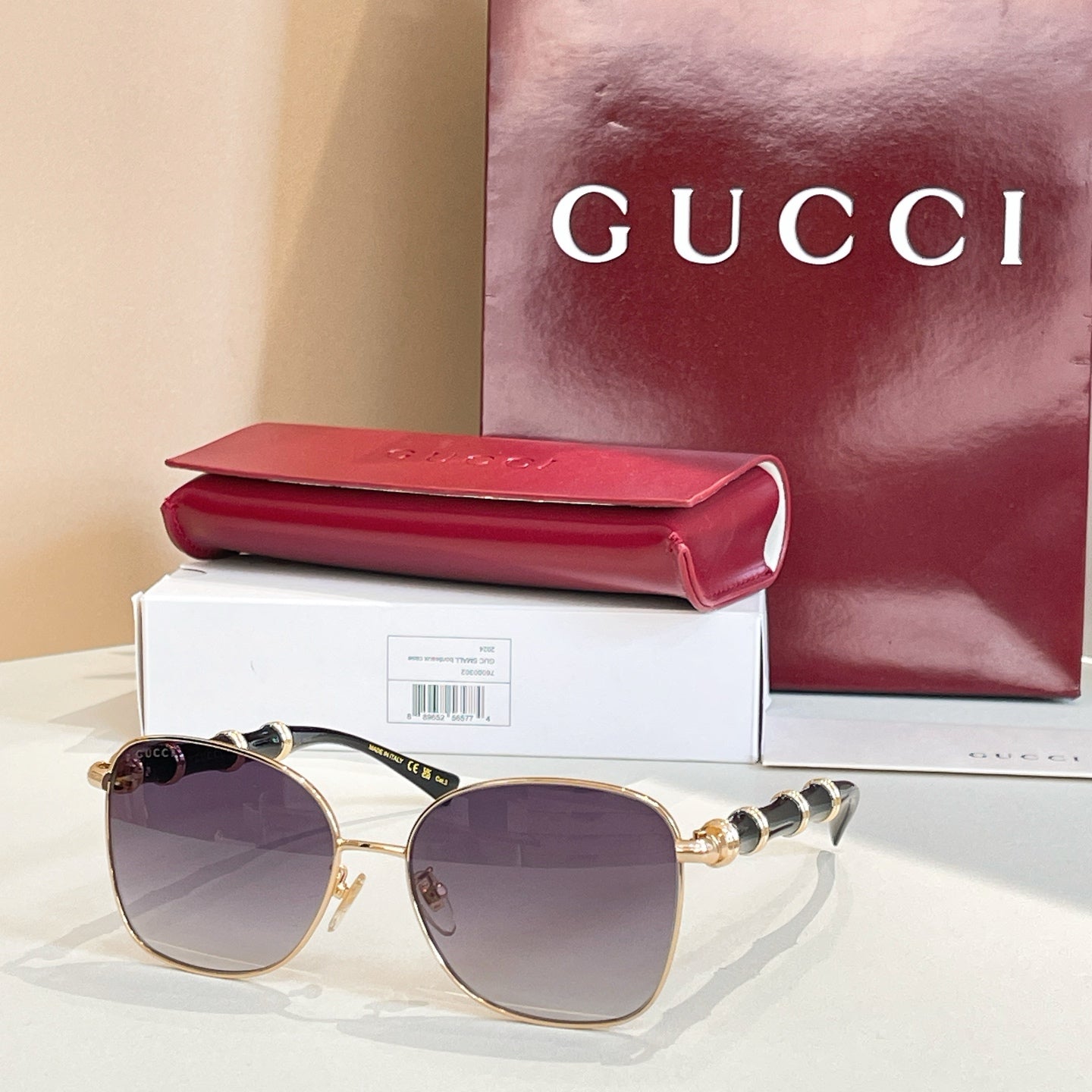 Gold metal round sunglasses with purple-tinted lenses and ornate black temple