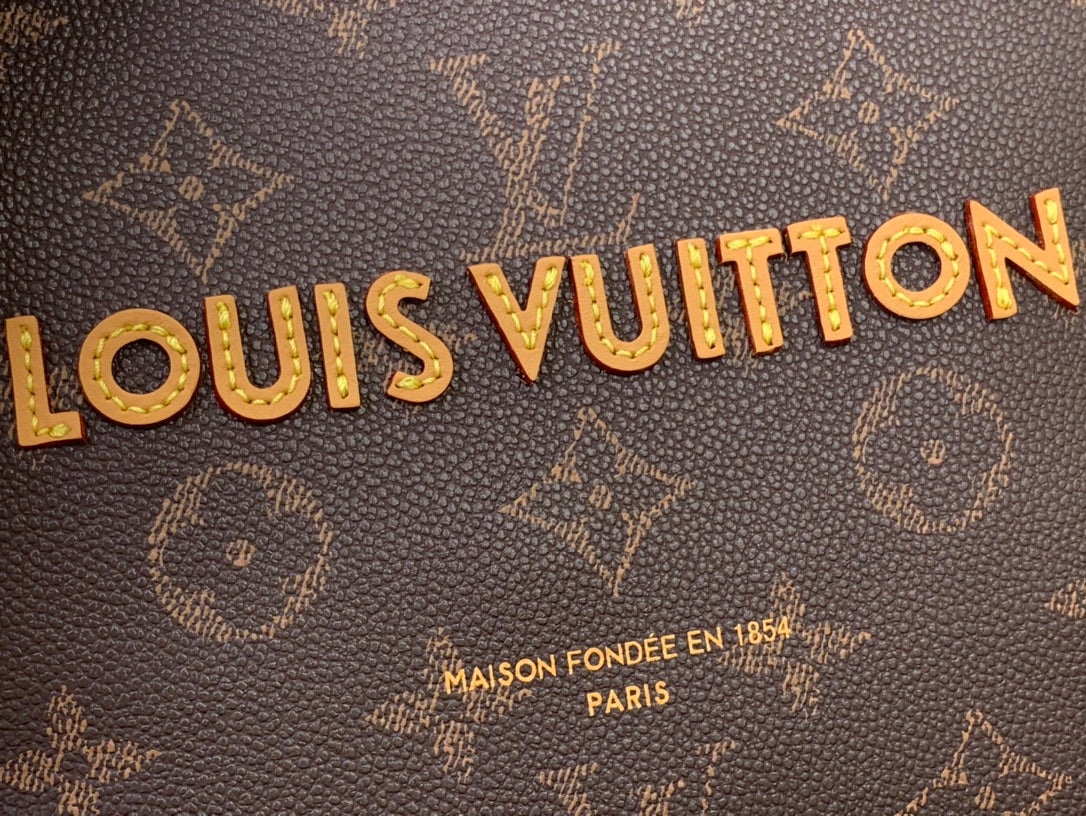 Louis Vuitton logo on dark brown monogram canvas with gold lettering