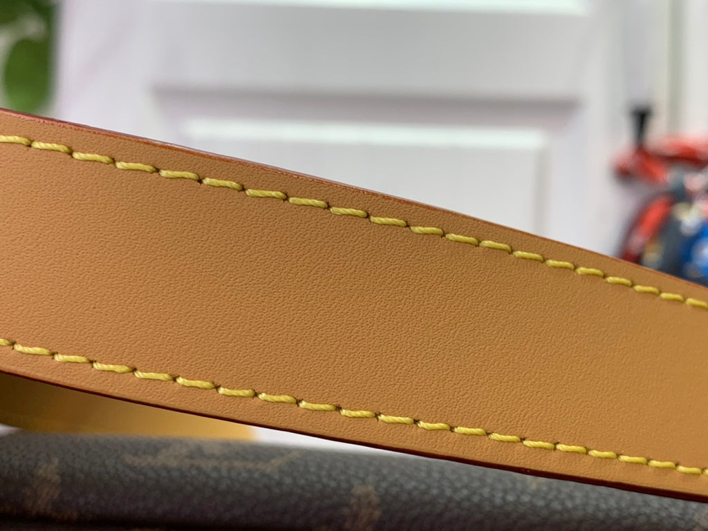 Tan leather strap edge with yellow stitching on Louis Vuitton bag