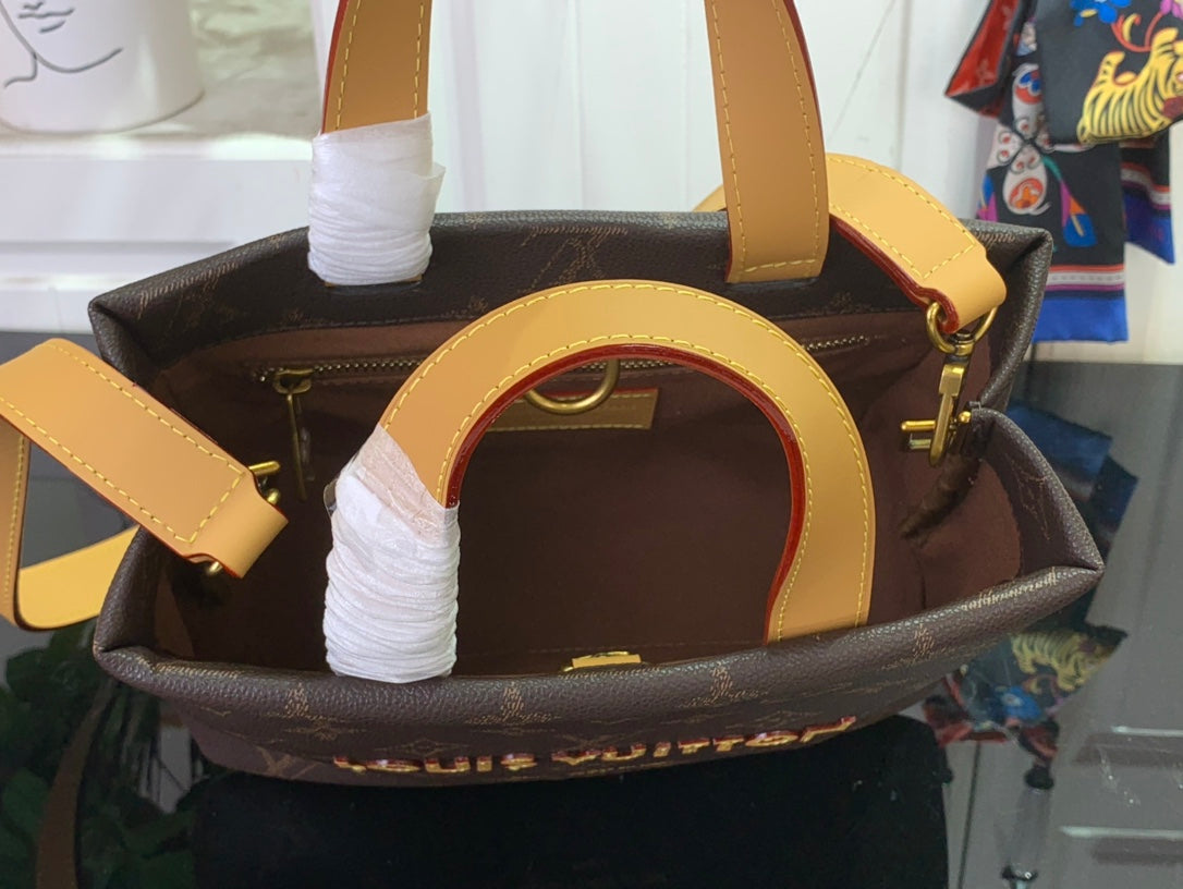 Louis Vuitton bag open with tan handles and lining, dark brown monogram exterior