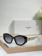 Celine sunglasses with black cat-eye frames, dark lenses, and gold emblem temple detail