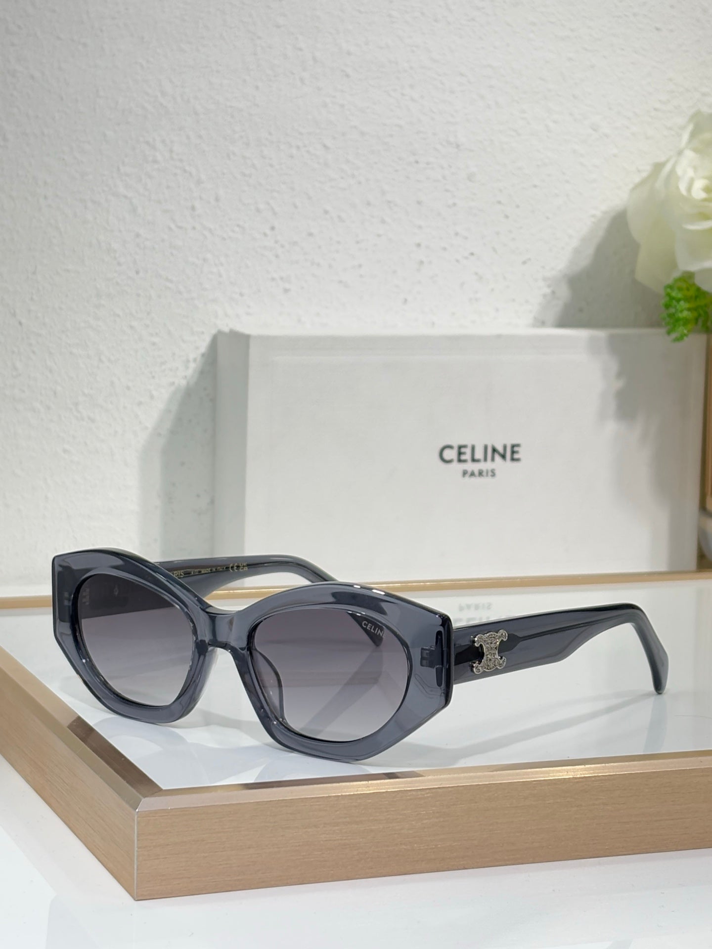 Celine sunglasses with black frames, tinted lenses, and gold logo on the side