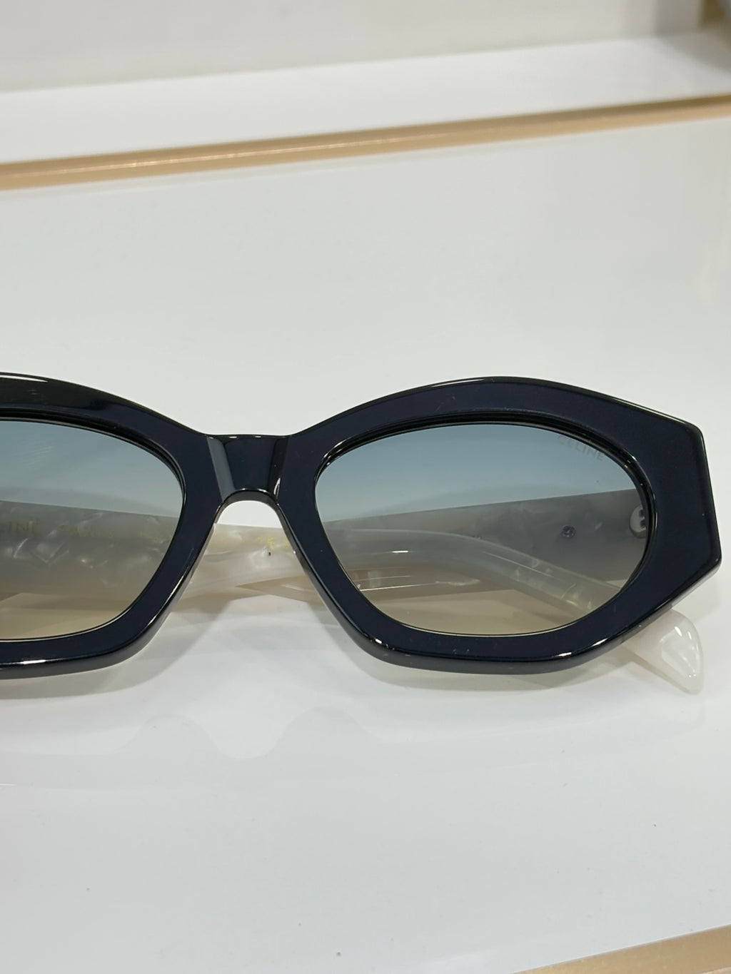 Close-up of Celine sunglasses with black oval frames and tinted lenses