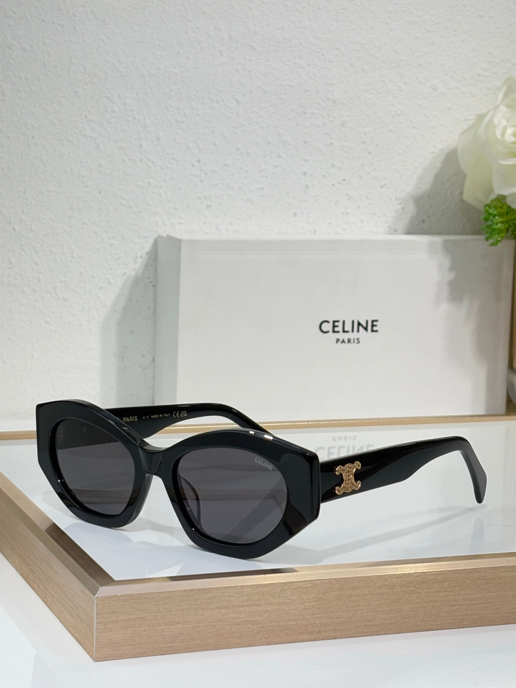 Celine sunglasses with black frames and dark lenses, with a gold logo on the temple