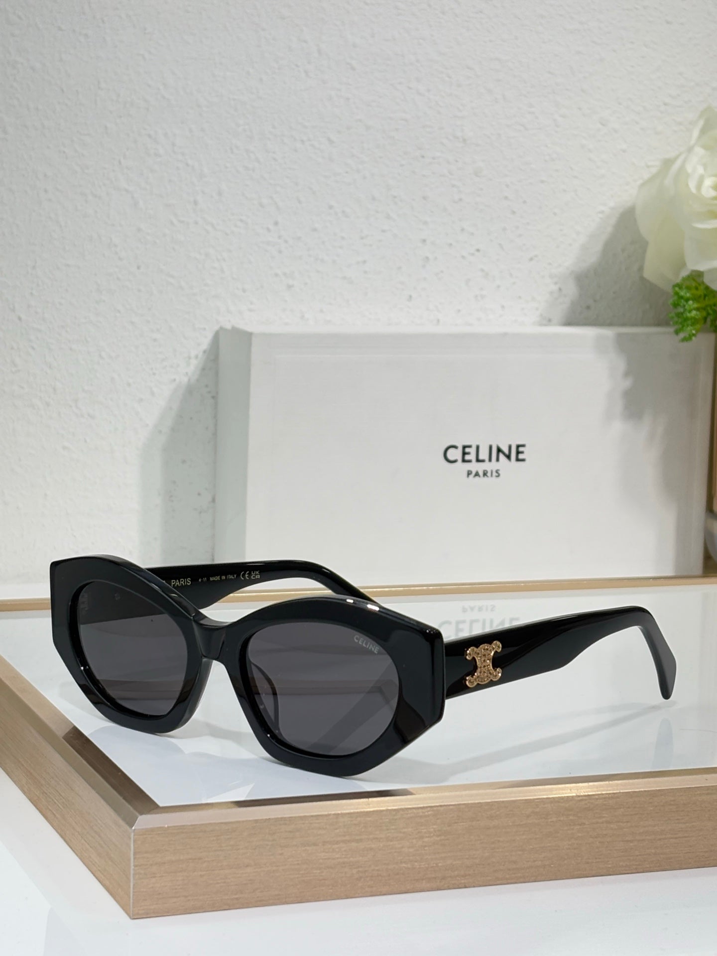 Celine sunglasses with black frames and dark lenses, with a gold logo on the temple