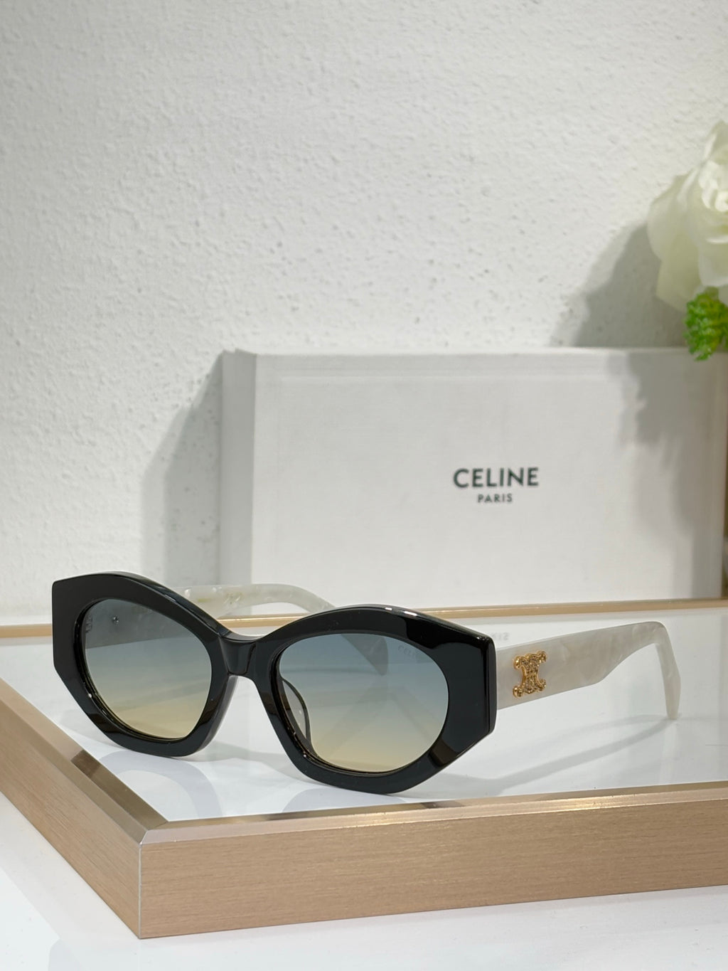 Celine sunglasses with black oversized frames, dark lenses, and gold logo at temples