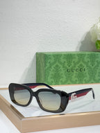 Gucci sunglasses with black frames and neutral lenses, cat-eye shape